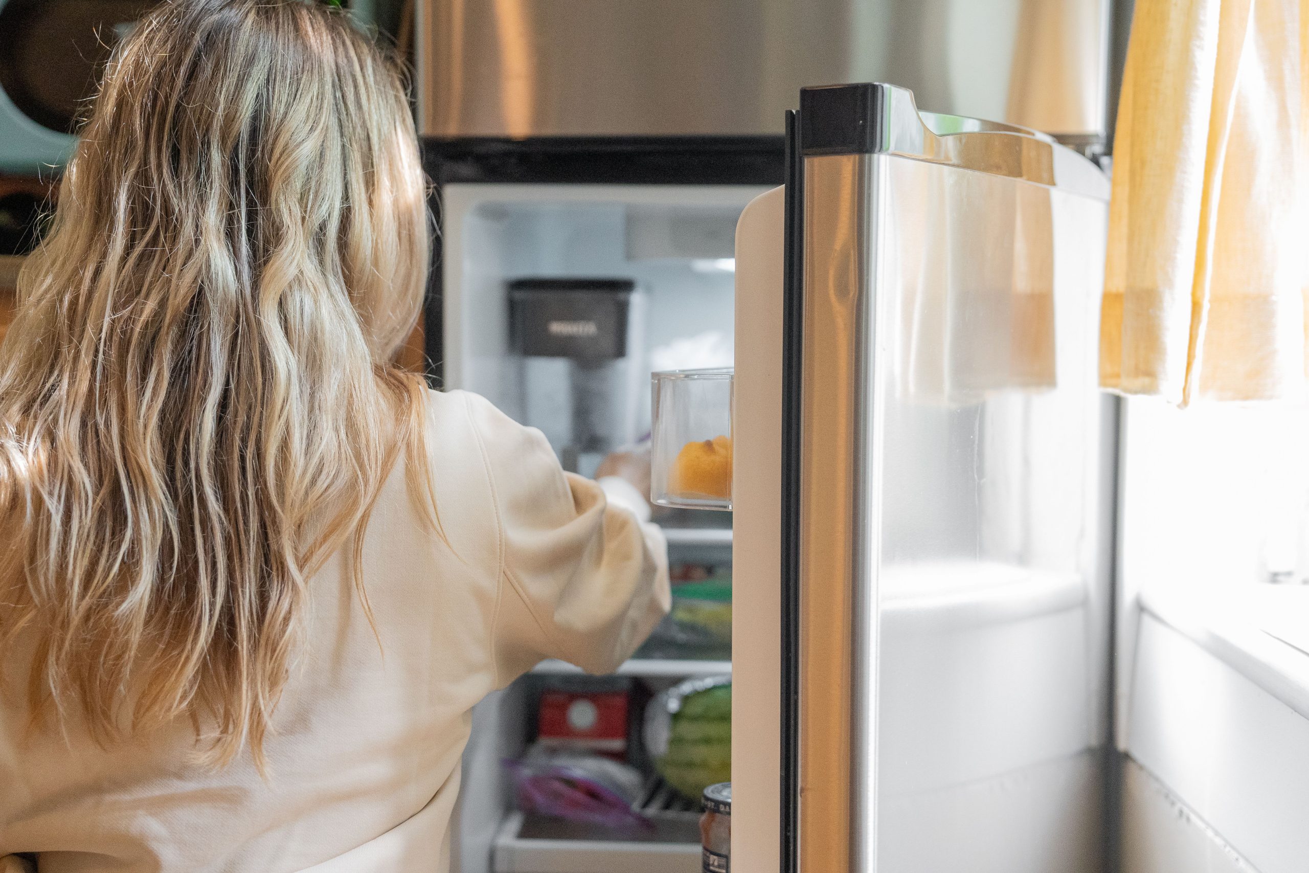 Femme récupérant aliments du frigo