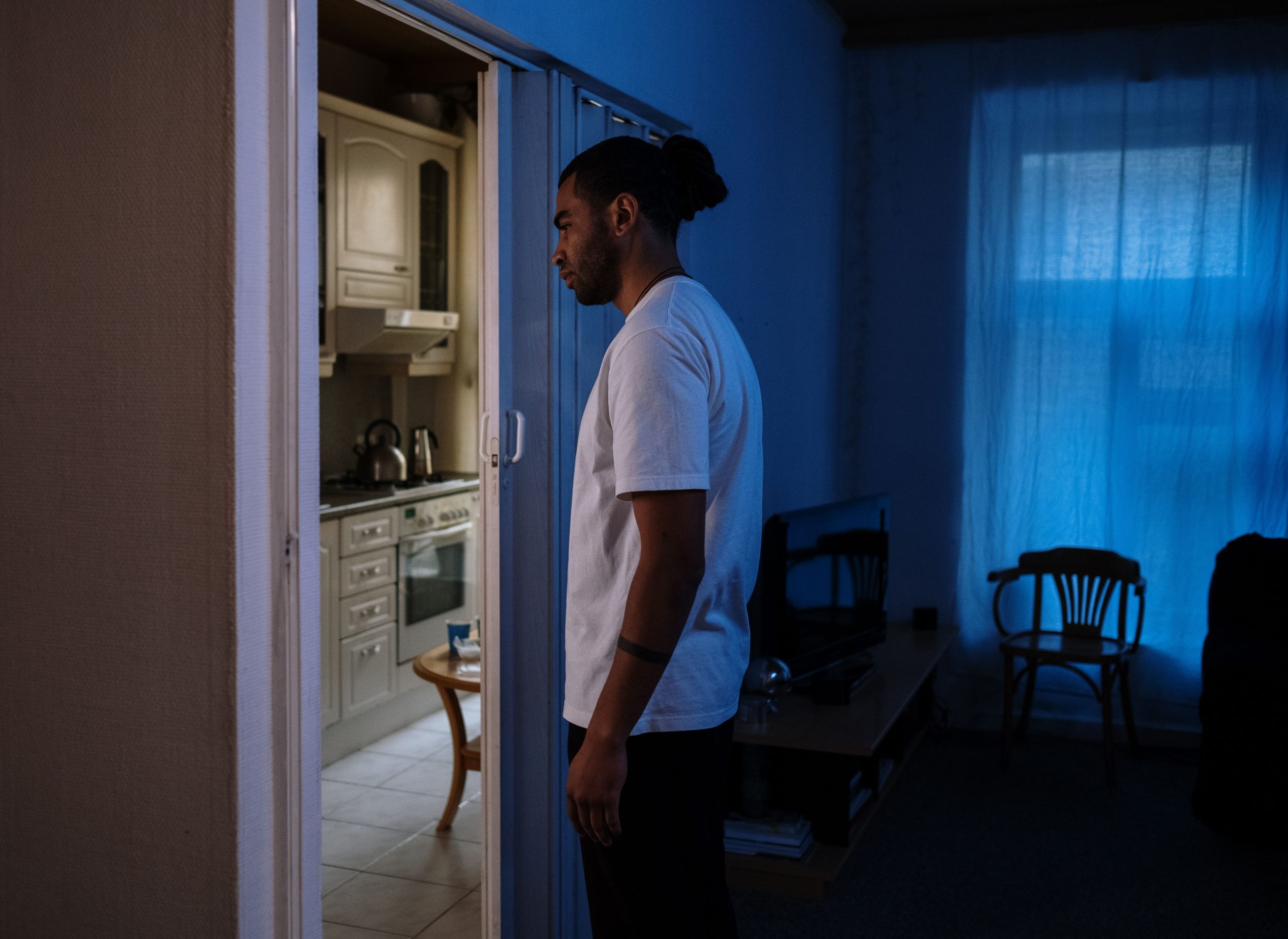 Homme en chemise blanche dans pièce sombre