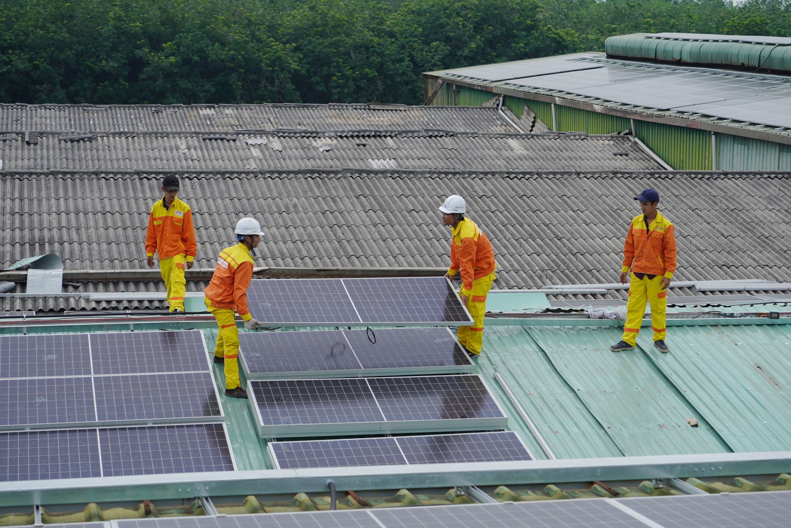 Ouvriers posant panneaux solaires toit durable