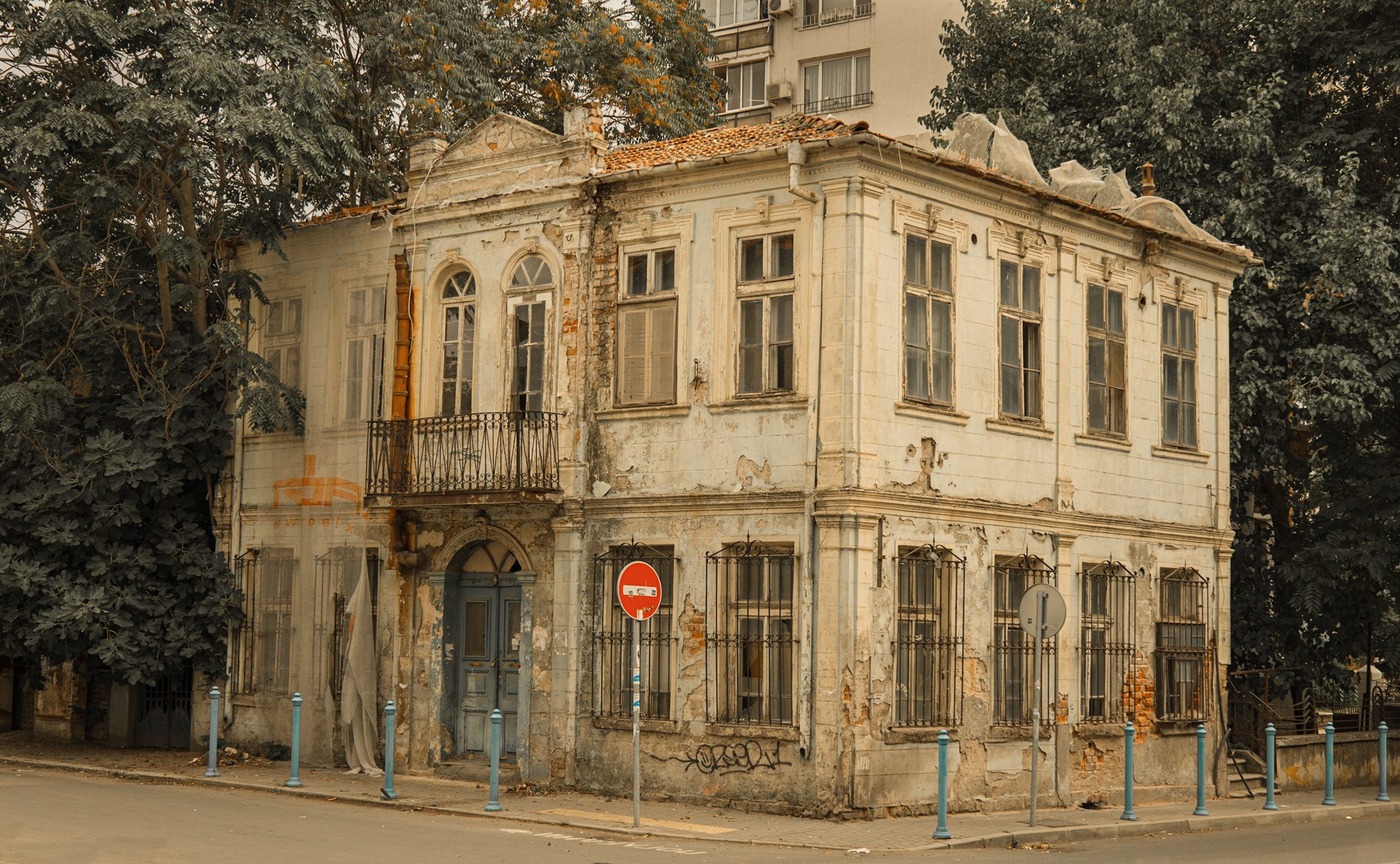 Bâtiment vieilli avec balcon et panneau interdiction