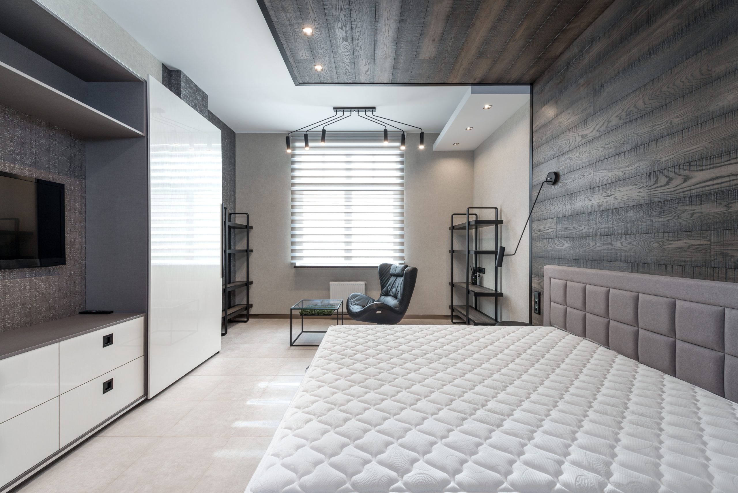 Lit contre mur avec TV et rangements blancs