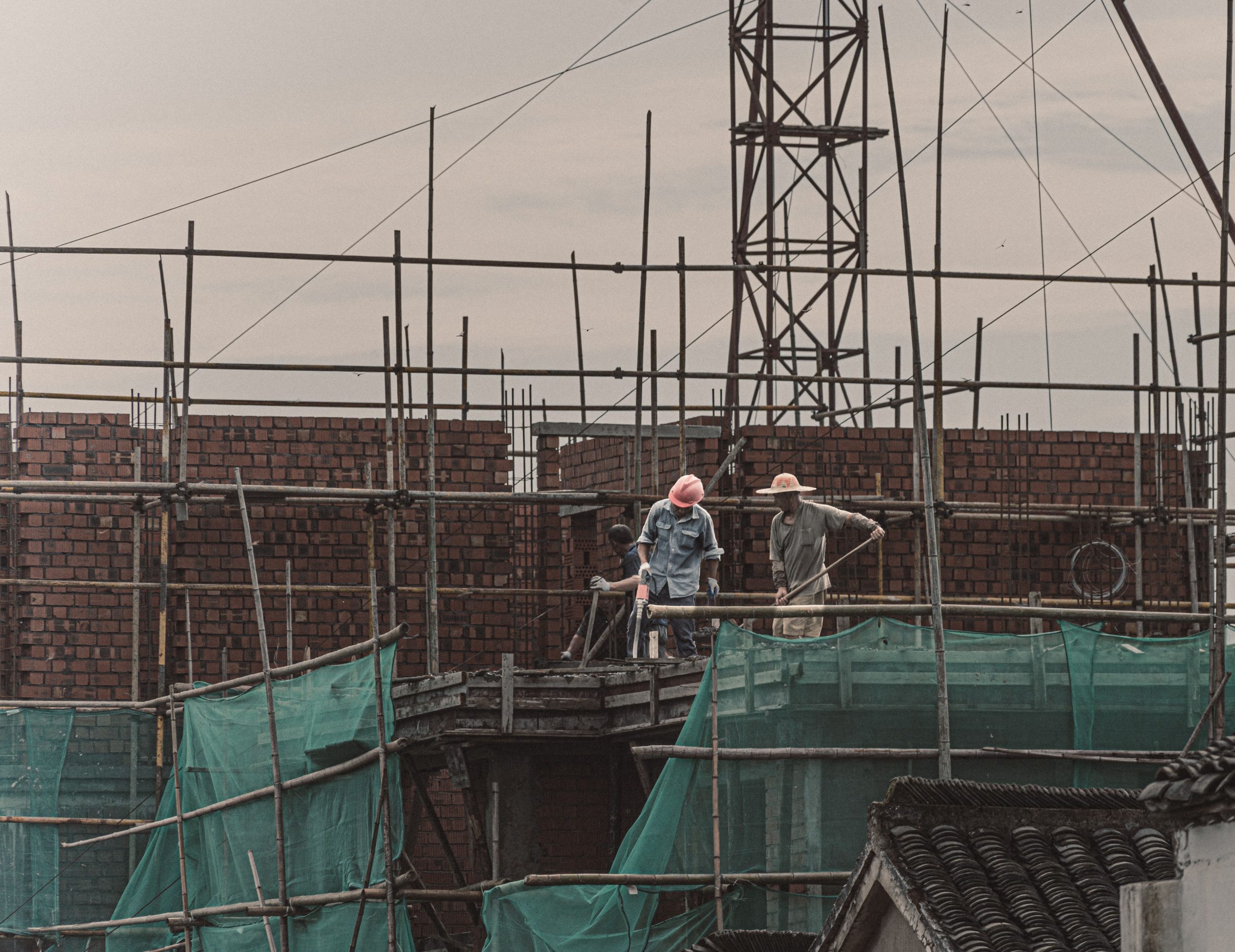 Ouvriers travaillant sur un mur de brique