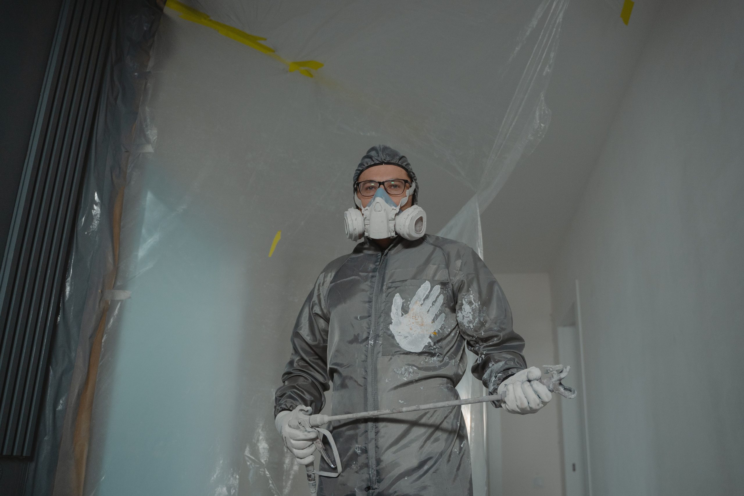Peintre en tenue de protection avec masque et lunettes