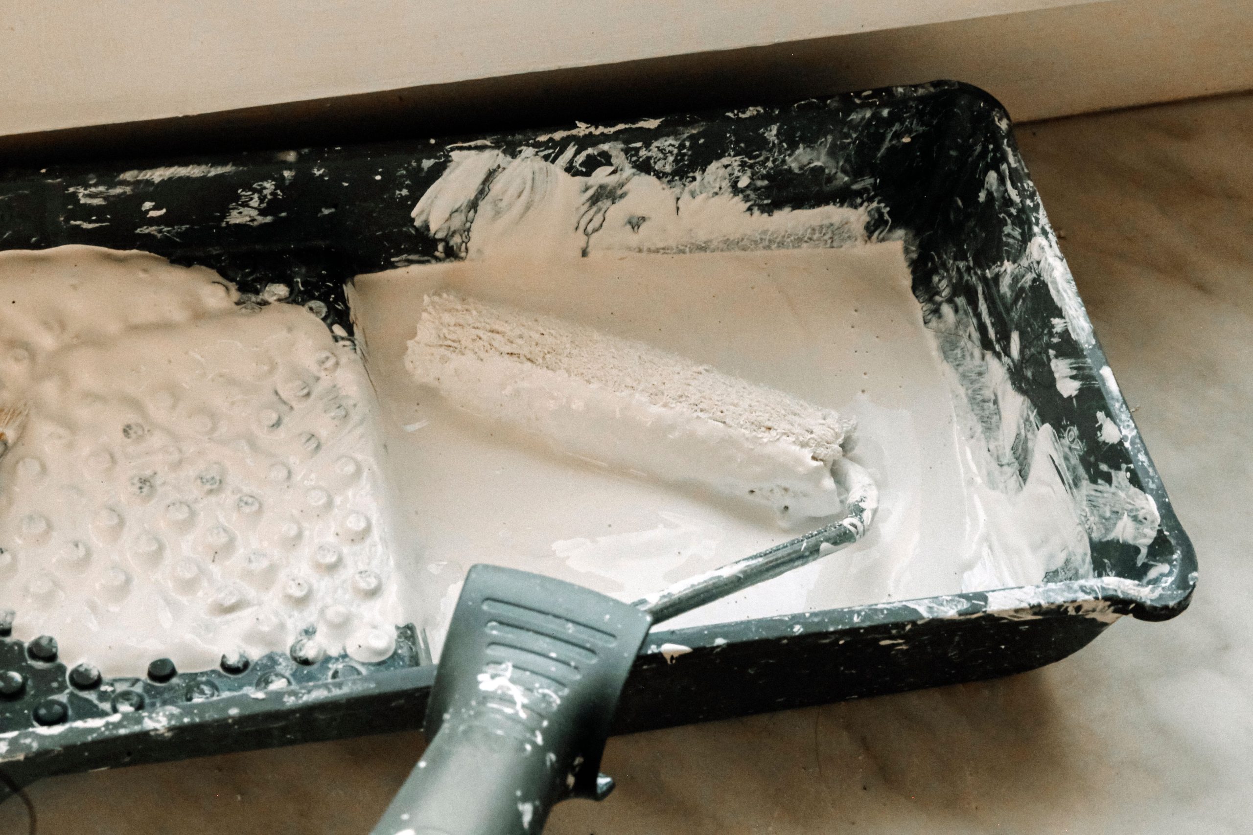Rouleau de peinture blanc dans un bac plastique