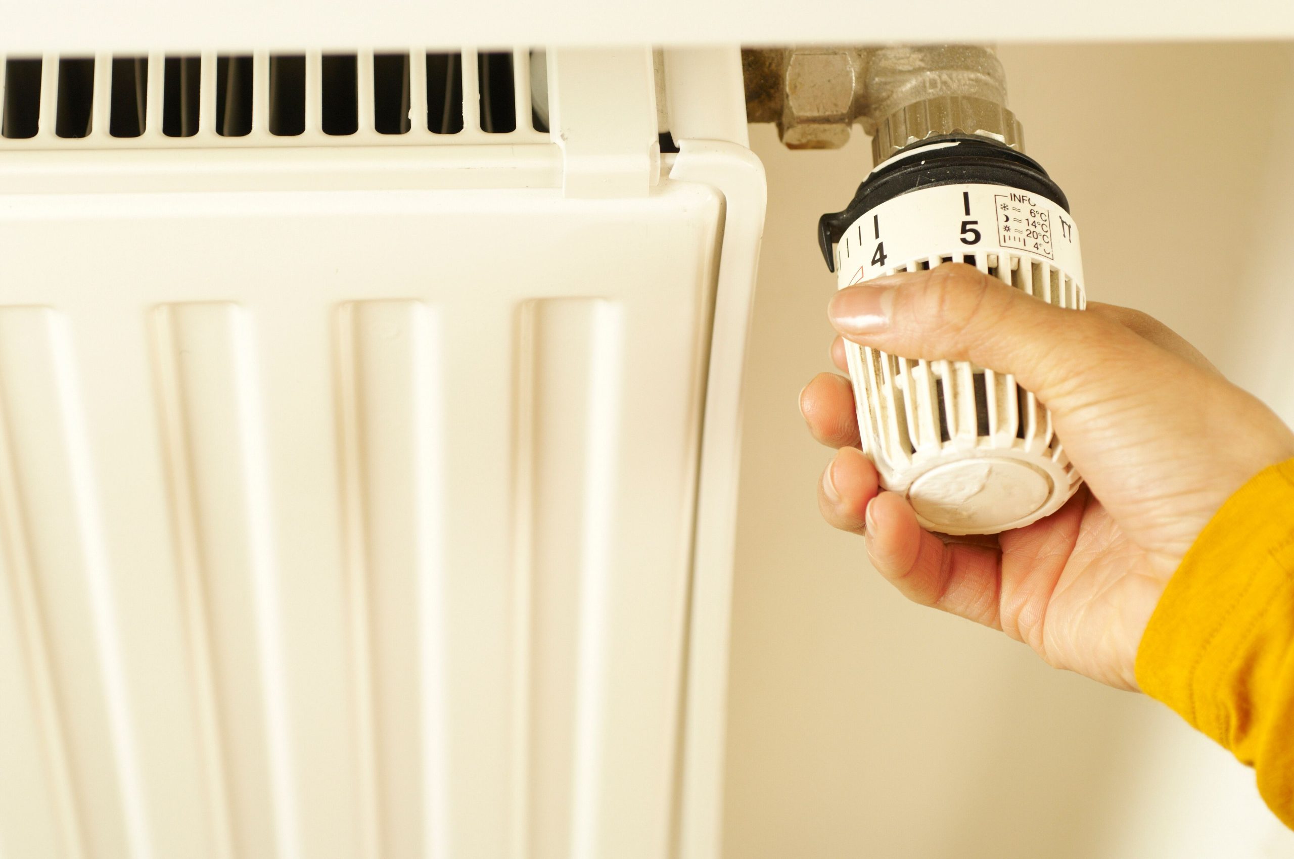 Main réglant le thermostat du radiateur