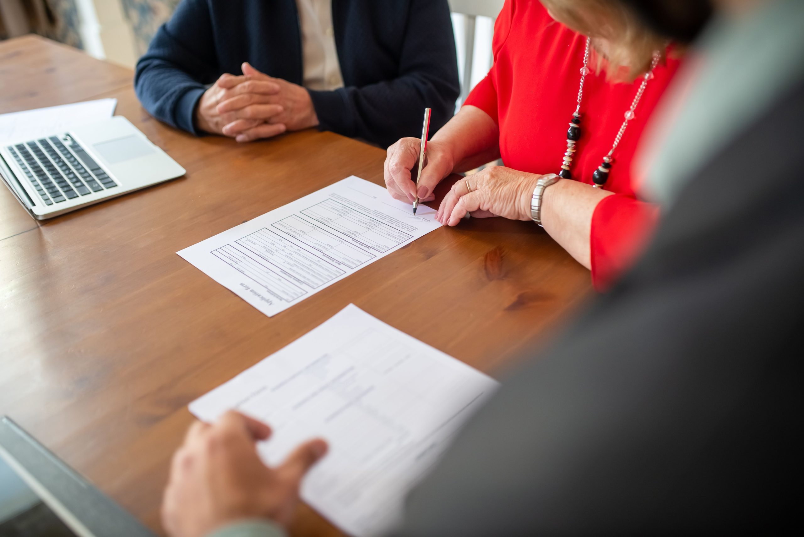Deux adultes signant des documents sur une table