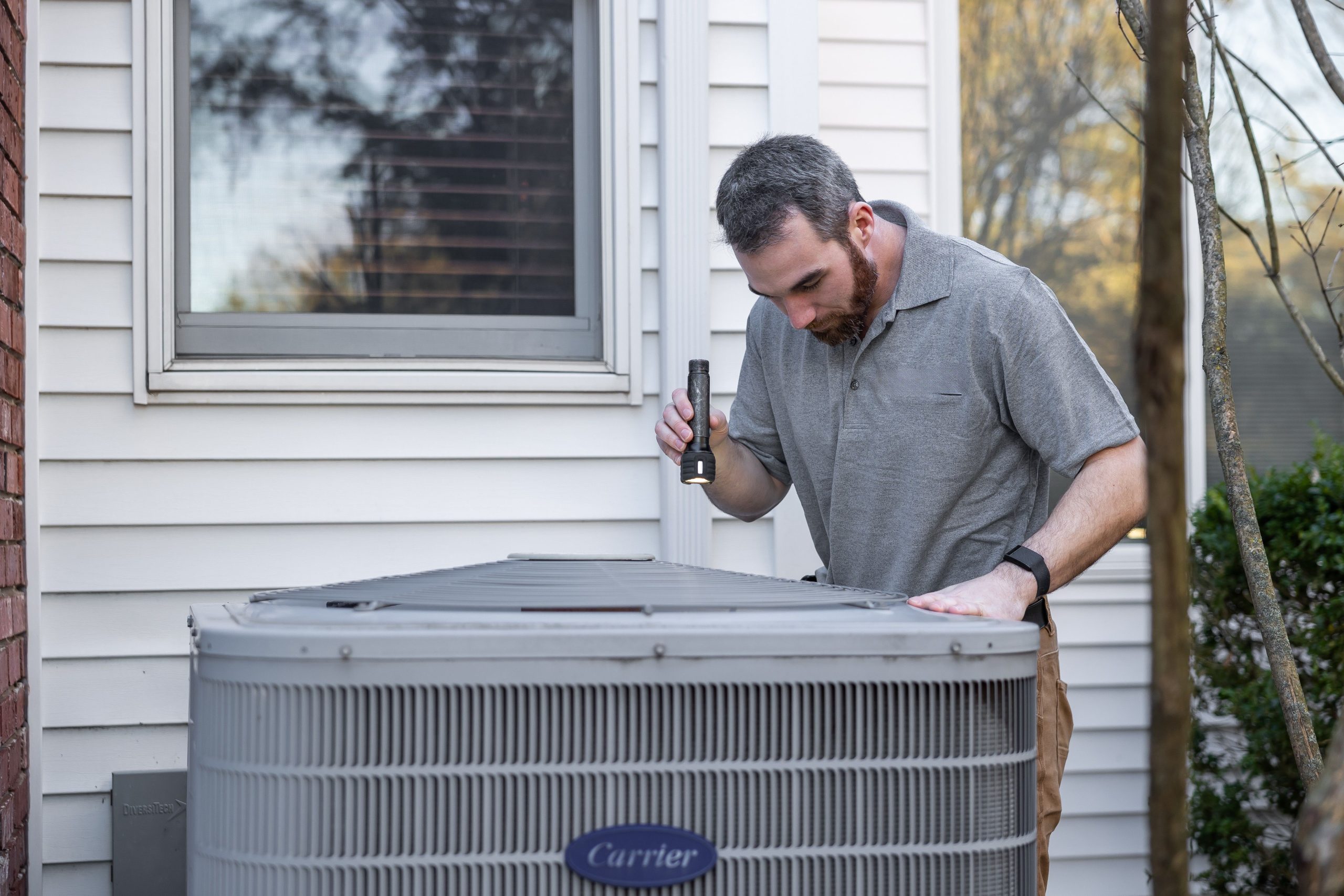 Technicien contrôlant unité climatisation extérieure
