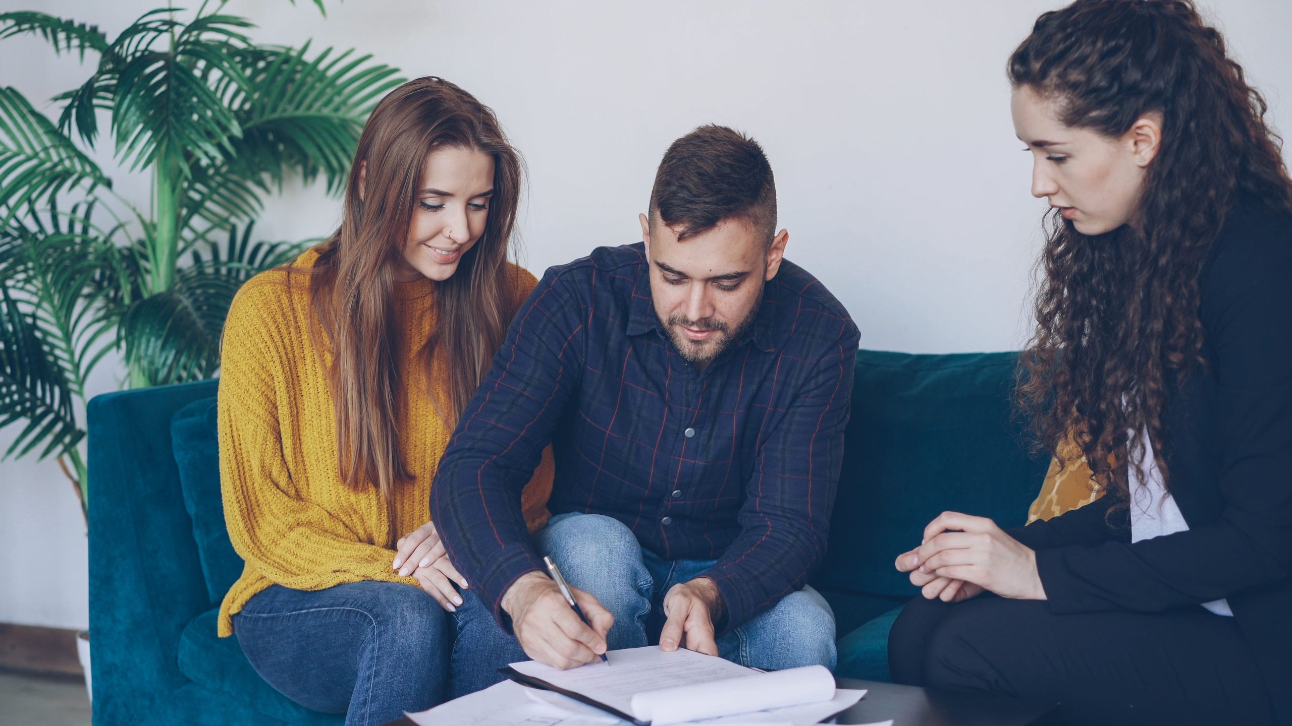 Jeune couple signant des documents avec un conseiller
