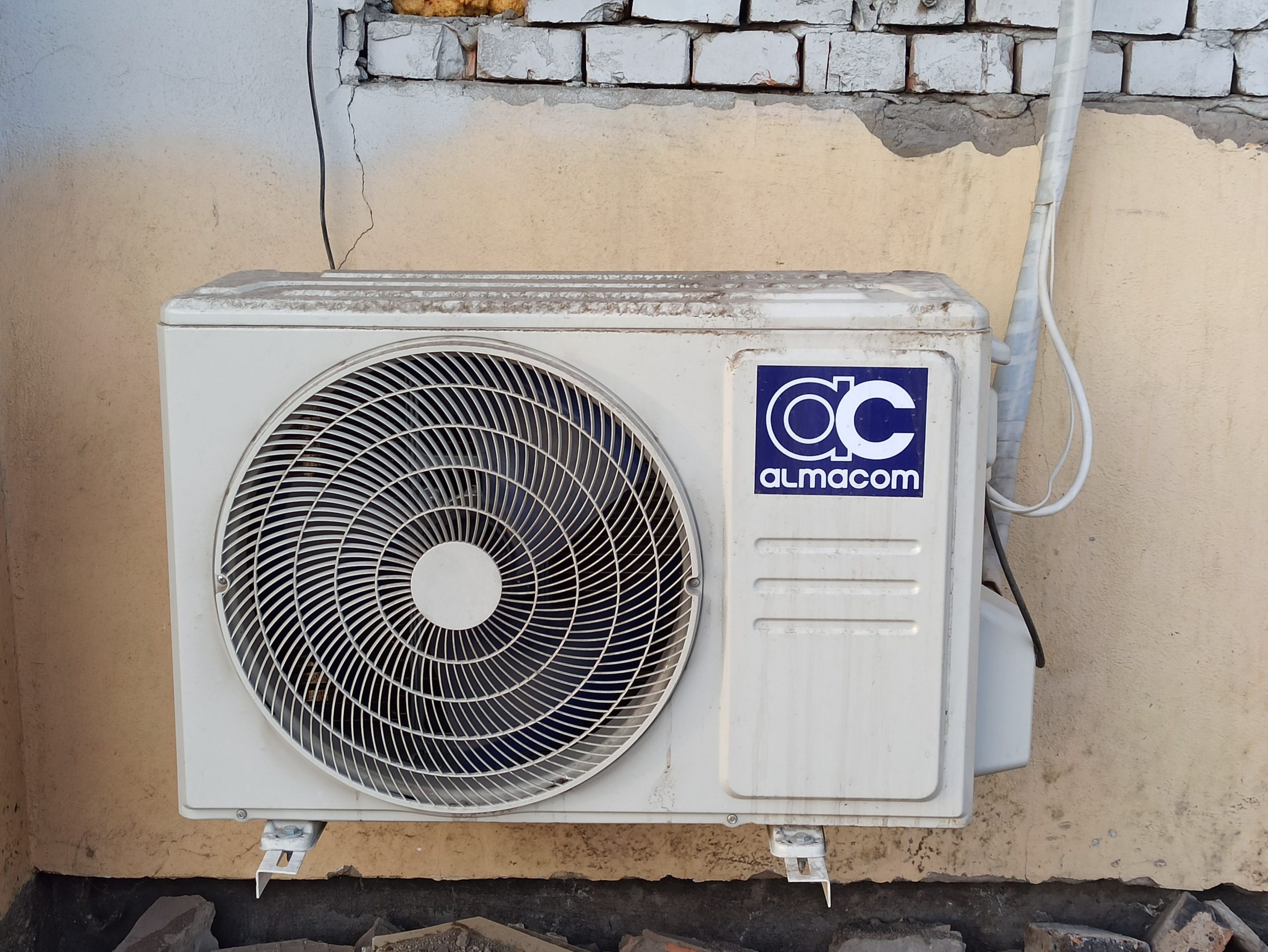 Unité de climatisation extérieure fixée sur mur de brique